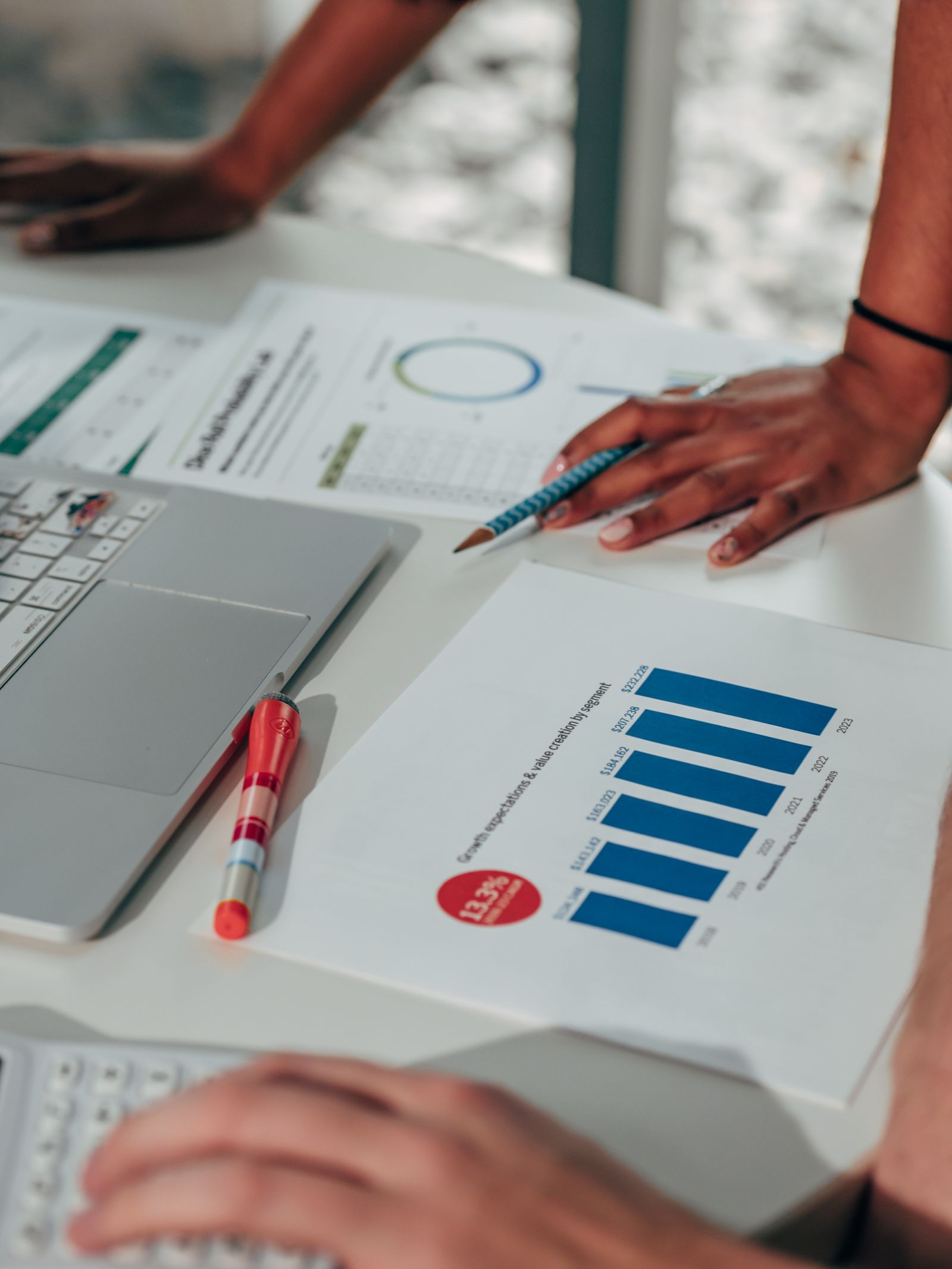 A business team reviews charts, documents and devices, illustrating the disconnected touchpoints in a buyer journey.