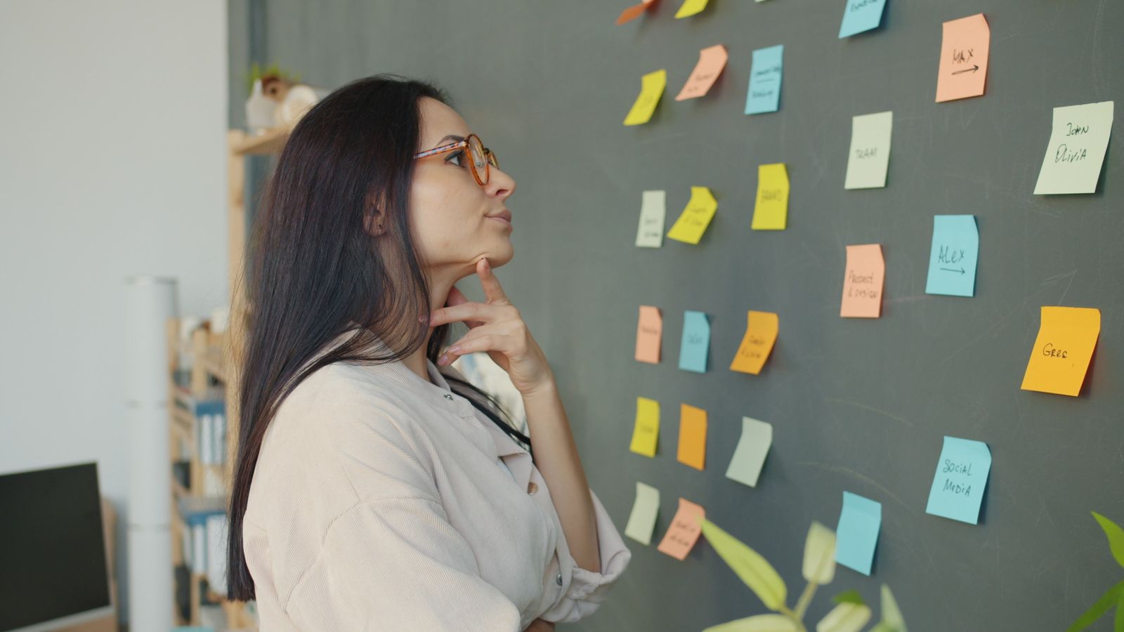 A strategist studies sticky-note ideas on a dark planning wall, illustrating the need to diagnose a business problem beyond campaigns.