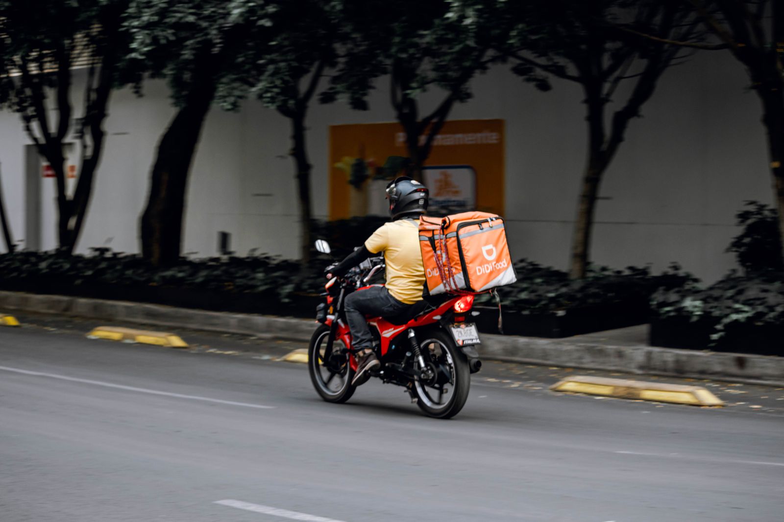 A delivery courier rides through a city, illustrating on-demand delivery operations rather than a Swiggy employee.